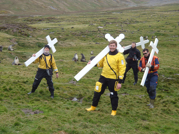 Four men carrying new crosses