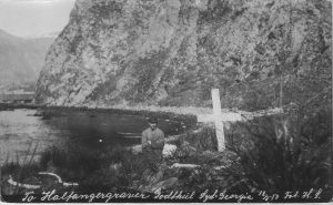 1917 photograph showing a man standing next to two graves at Godthul.